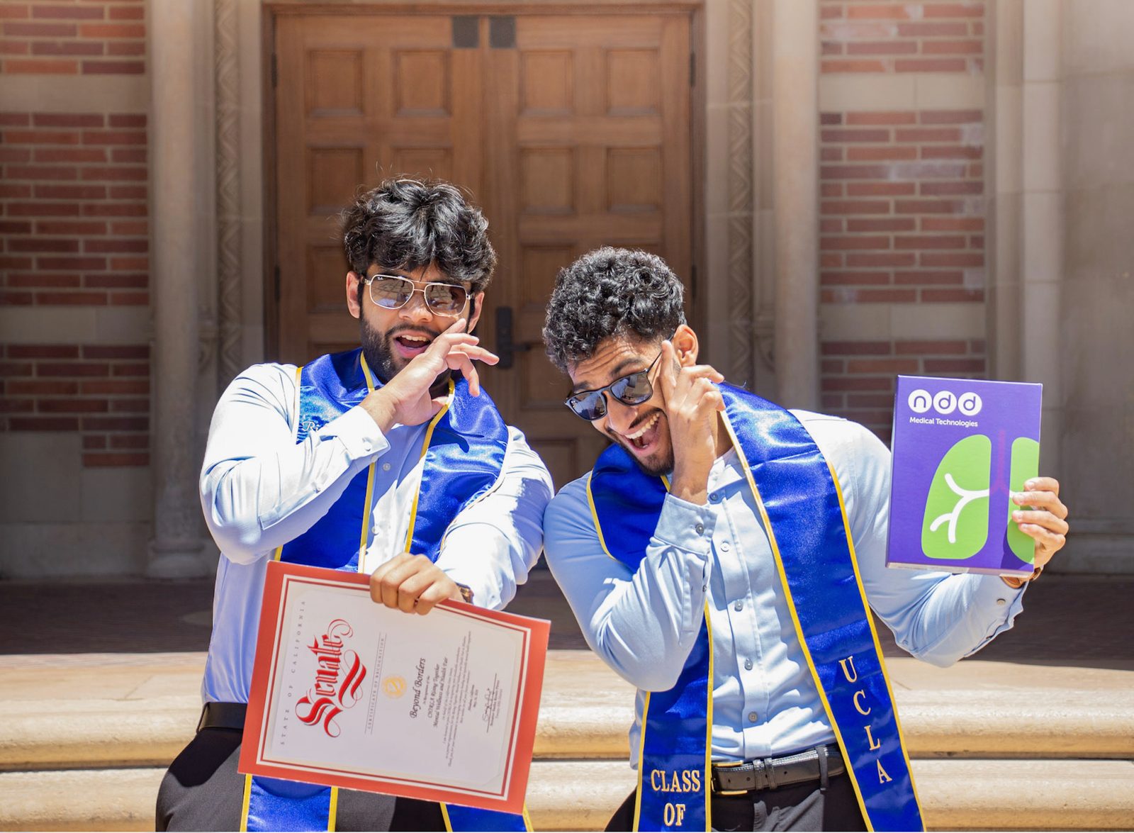 Zaid Vellani and Rishit Bhat celebrating outside a UCLA building